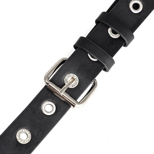 Detailed macro view of black leather belt with silver buckle and rhinestone eyelets