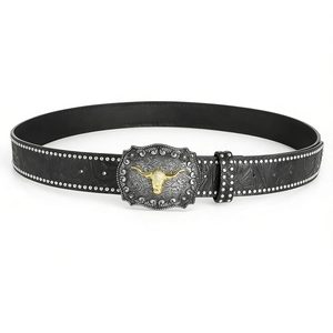 Detail of western cowboy belt with embossed black leather and golden bull head buckle