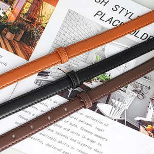 Close-up of slim leather belts in brown, black, and coffee with fine stitching and pin buckles