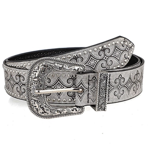 Detailed macro view of western silver embossed leather belt with floral buckle and rivets