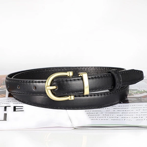 Close-up of black leather belt with golden U-shaped buckle on a magazine background