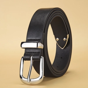 Détail de la ceinture en cuir noir montrant le grain fin et la boucle métallique argentée