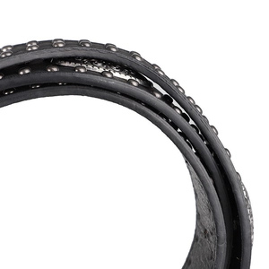 Détail de la ceinture en cuir noir fin avec rivets argentés montrant le style punk rock