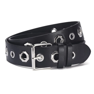 Détail de la ceinture en cuir noir punk avec des œillets en forme d'étoile et boucle en métal