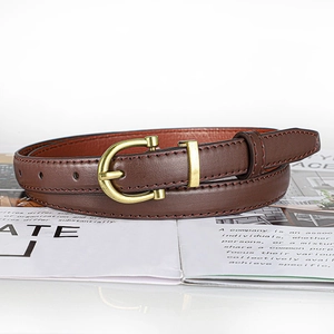 Detail of a slim dark brown leather belt with a classic golden horseshoe metal buckle