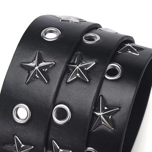 Détail de la ceinture punk en cuir noir avec clous étoiles argentés et œillets