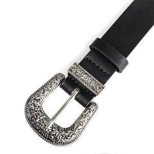Macro shot of vintage Western-style belt with engraved silver buckle and black leather