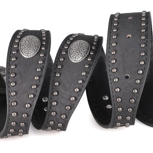 Détail de la ceinture vintage en cuir noir avec rivets métalliques et plaques gravées