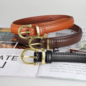 Detail of slim leather belts with gold D-shaped buckles in black, brown and tan colors