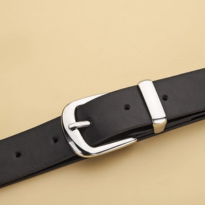 Gros plan d'une ceinture en cuir noir avec boucle fer à cheval argentée et grainée