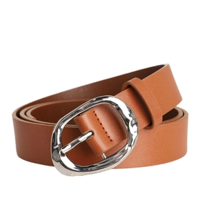 Détail d'une ceinture en cuir marron avec une boucle irrégulière en métal argenté martelé