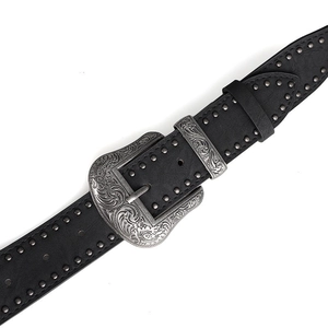 Gros plan détaillé d'une ceinture en cuir noir vintage avec boucle argentée et rivets en métal