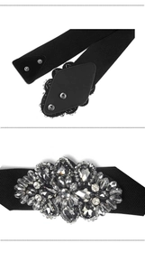 Détail d'une ceinture élastique noire avec cristaux strass et boutons-pression argentés