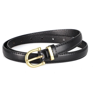 Close-up of black leather belt with gold horseshoe buckle and neat edge stitching details