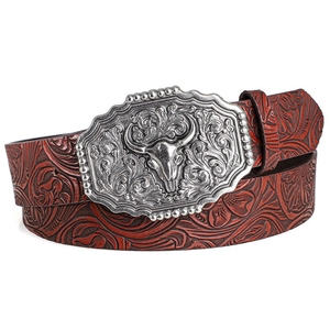 Close-up of western leather belt with embossed floral patterns and silver bull head buckle