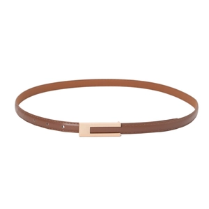 Close-up of slim dark brown leather belt with elegant hollow gold metal buckle