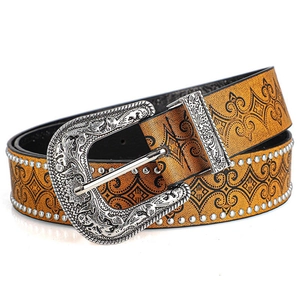 Detail of western cowboy belt with vintage engraved buckle and silver rivet studs