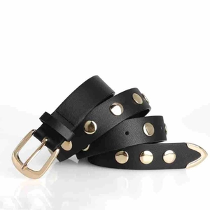 Detail of black punk leather belt featuring gold round studs and polished buckle