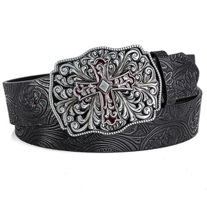 Detailed macro of vintage black embossed leather belt with ornate silver cross buckle