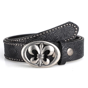 Détail d'une ceinture en cuir noir rétro avec boucle fleur de lys et rivets en métal