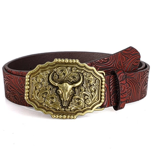 Detail of western cow head alloy buckle with floral embossed leather belt for men