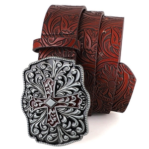 Detail of vintage embossed belt with large silver cross buckle and floral scroll patterns