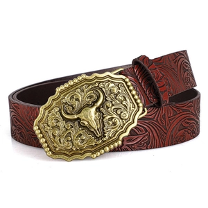 Vintage western leather belt featuring embossed floral patterns and a bronze bull skull buckle