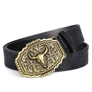 Detailed macro view of vintage bull head metal buckle on floral embossed leather belt
