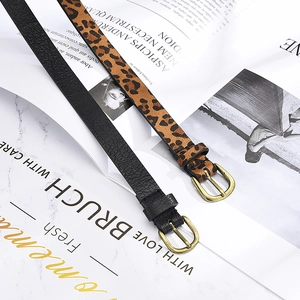 Detail of slim black and leopard print belts with vintage gold buckles on a magazine