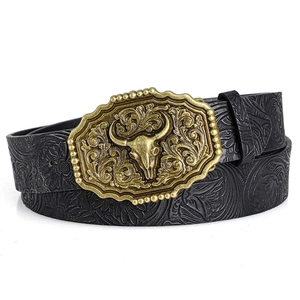 Detailed view of the antique bronze bull head buckle and embossed floral leather belt