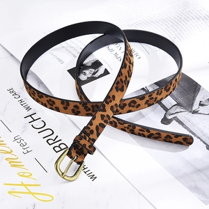 Detailed macro view of a leopard print thin leather belt with a vintage gold metal buckle