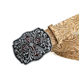 Close-up of vintage metal cross buckle and detailed floral carving on leather belt