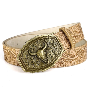 Close-up of vintage bull skull buckle and floral embossed beige leather western belt