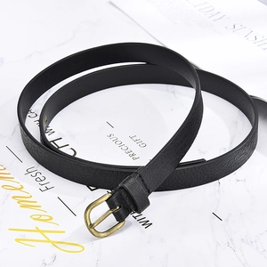 Slim black lychee leather belt for women with vintage brass buckle on marble background