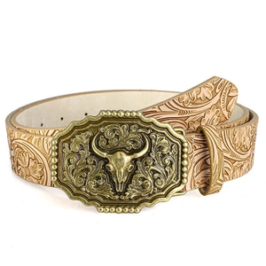 Detail of vintage bull head buckle on embossed floral leather belt with bronze finish