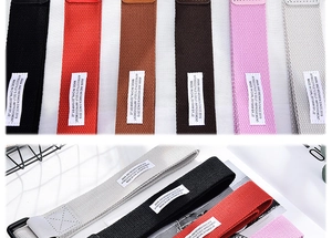 Close-up of woven canvas belts in multiple colors with high-density fabric texture