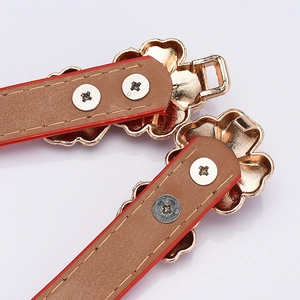 Women's red patent leather belt with a golden flower buckle shown in detail