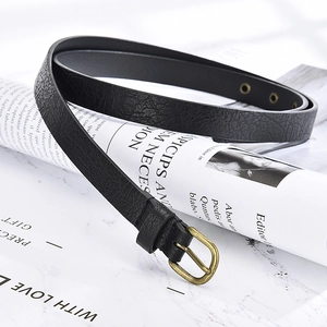 Close-up of black leather thin belt with vintage bronze buckle on marble background
