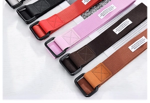 Detail of multi-color canvas belts with matte black double D-ring buckles and woven labels