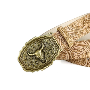Detail of western bull skull alloy buckle and embossed floral leather belt strap