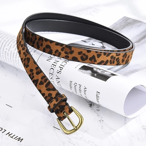 Close-up of leopard print faux suede belt with vintage metal buckle on marble surface