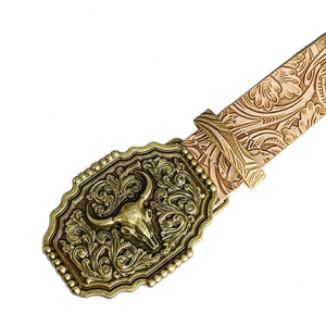 Close-up of vintage bull head buckle and floral embossed pattern on western belt