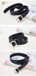 Detailed view of black faux leather belts with various gold and silver metal buckles
