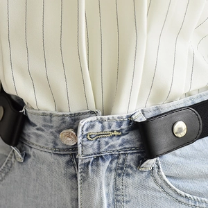 Close-up of black buckle-free elastic belt attached to denim jeans showing metal snap buttons