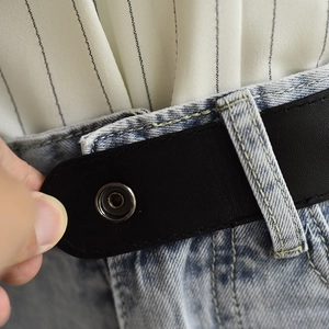 Detail of black elastic belt showing snap button attachment on blue jeans