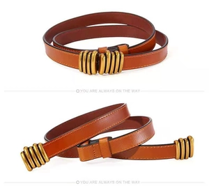 Close-up of slim brown leather belt with vintage gold textured multi-ring buckle