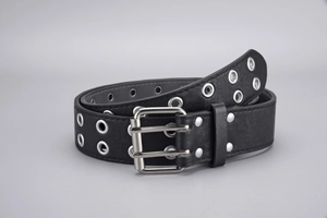 Detail of a black punk leather belt featuring silver double eyelets and a sturdy square buckle