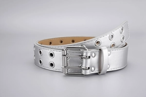 Detail of silver punk belt featuring dual pin buckle and metallic eyelet decorations