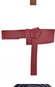 Detail of burgundy wide faux leather corset belt with knotted fastener for women