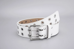 Close-up of a white punk leather belt with double grommet holes and a silver metal buckle